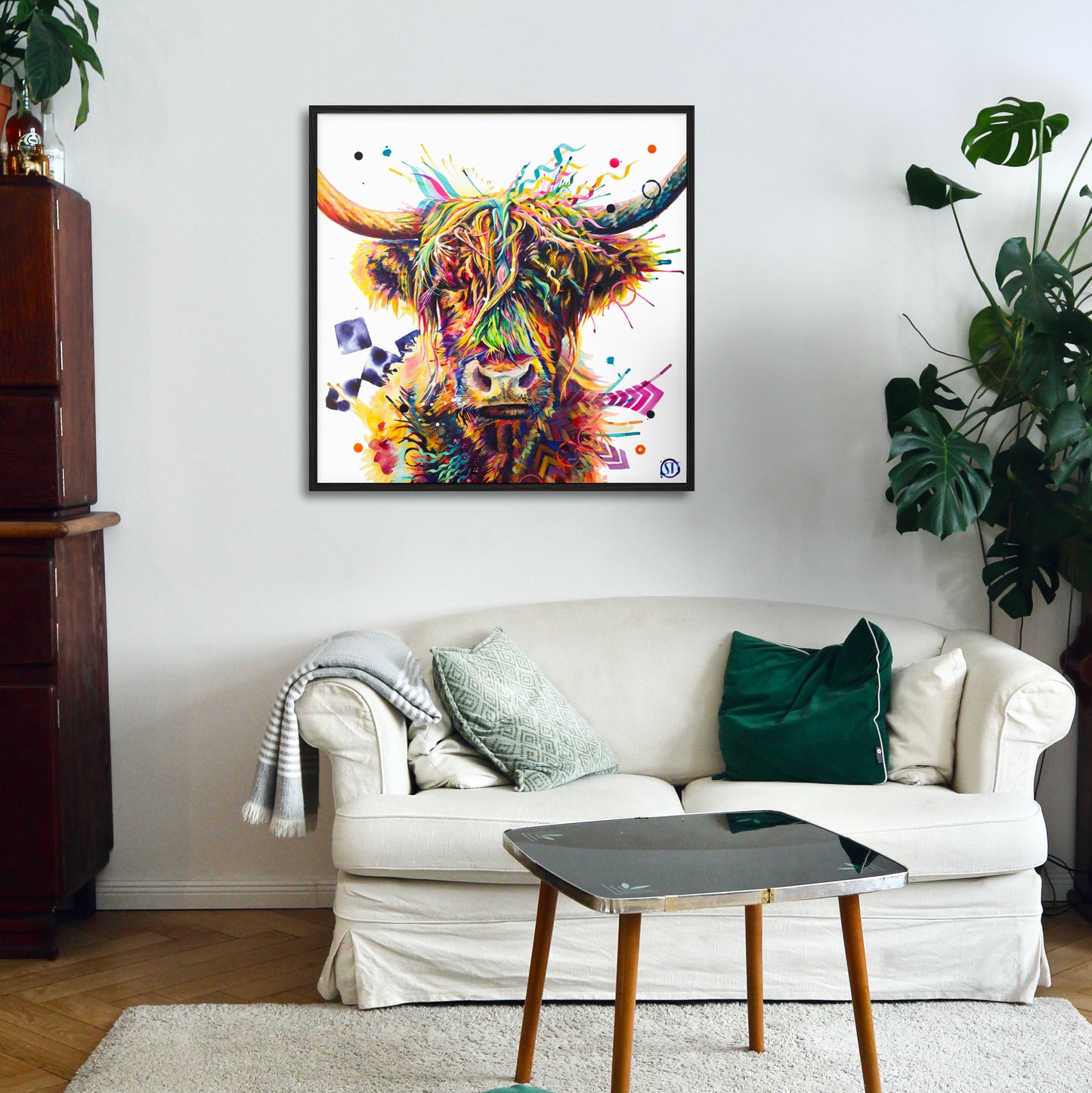 A colorful framed highland cow painting  hanging above a white sofa in a modern living room setting.
